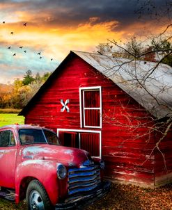 Red Truck and Red Barn under Sunset Skies