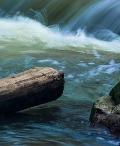 Log And Boulder Beneath Slow Waterfalls