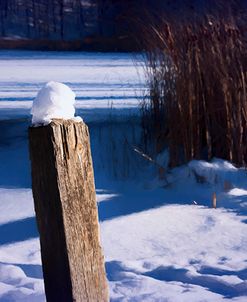 Snow Capped Fence Post Along Pond