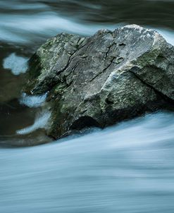 Large Jagged Boulder In Slow Flowing Water