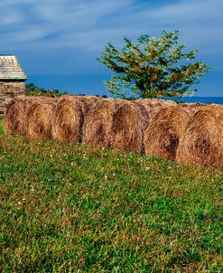 Large Round Haybales With Stone Barn
